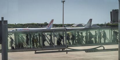 Un grupo de pasajeros accede a un avi&oacute;n desde la terminal 1 del aeropuerto de Barcelona-El Prat.