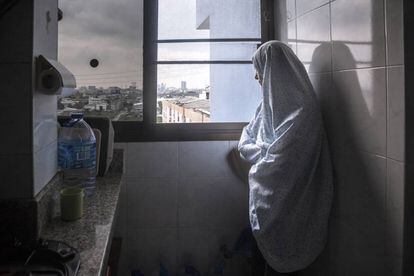 La familia mujer de Tamim, que no quiere decir su nombre, mira por la ventana desde el piso en el que vive encerrada desde hace dos años.