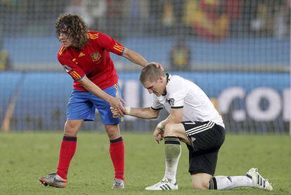 Puyol consuela a Schweinsteiger tras el partido.