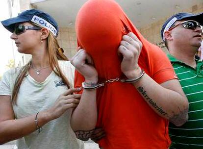 Uno de los detenidos es llevado esposado por policías ante un tribunal en Ramle, cerca de Tel Aviv.