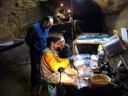 Svante Pääbo (derecha), Antonio Rosas y Carles Lalueza-Fox (de pie) analizan restos fósiles en la cueva de El Sidrón (Asturias) en 2007.