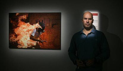 Ronaldo Schemidt ganador del WPP 2018 junto a la fotografía premiada de un joven envuelto en llamas.