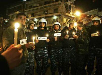 Un grupo de antidisturbios palestinos sostiene unas velas y se une a la protesta anoche en la ciudad de Gaza contra el <i>apagón.