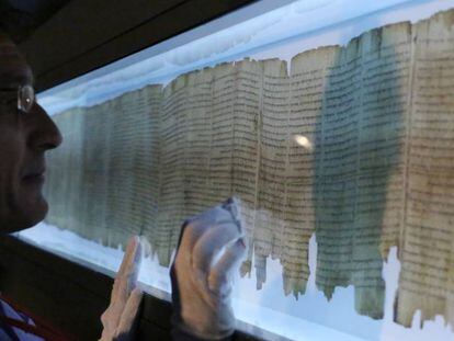 Un conservador de los Manuscritos del Mar Muerto los examina durante una exposición en 2014 en Hong Kong.