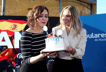 La presidenta de la Comunidad de Madrid, Isabel Diaz Ayuso, sopla las velas de una tarta junto a la diputada Noelia Núñez para celebrar el aniversario de las elecciones del 4-M.