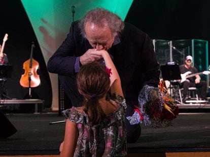 El artista agradeciendo el ramo de flores que le ofrece una niña durante su concierto en el Palau de les Arts.