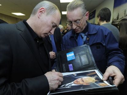 El presidente ruso, Vladimir Putin, firma un aut&oacute;grafo.