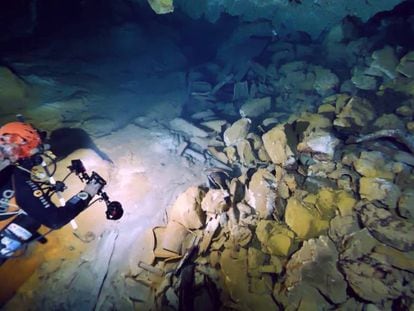 Un arqueólogo submarinista, junto a las ánforas romanas halladas en el interior de la cueva de la Fuente de Ses Aiguades en la bahía de Alcudia (Mallorca). En vídeo, el misterio arqueológico de la cueva de Ses Aiguades.