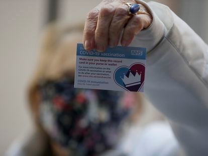 La británica Lyn Wheeler muestra su tarjeta de vacunación tras serle administrada la vacuna de Pfizer-BioNTech COVID-19 en un hospital de Londres.