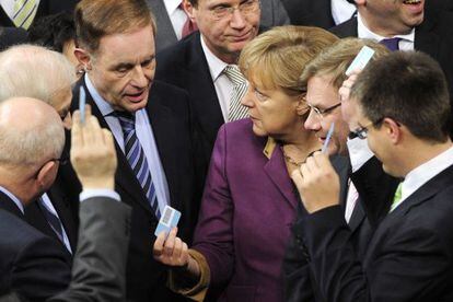 Angela Merkel rodeada de diputados en el Bundestag.