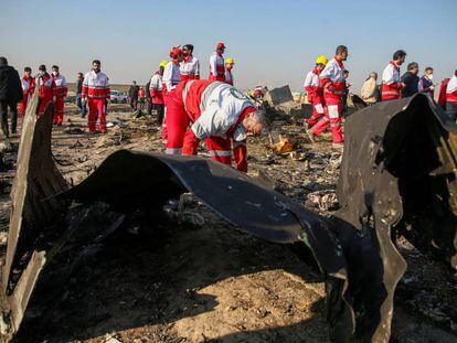 Trabajadores de la Media Luna Roja revisan los escombros del avión de Ukraine International Airlines, en las afueras de Teherán.