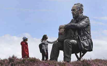 Dos visitantes observan el 'Hombre sentado', una escultura de tres metros del artista Sean Henry, en Castleton Rigg (Inglaterra).