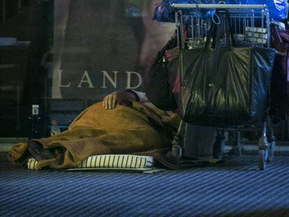Una persona sin techo duerme en una calle del distrio de L&#039;Eixample.