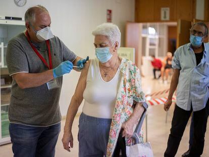 Un sanitario administra la tercera dosis a una mujer en un punto de vacunación de Sevilla.