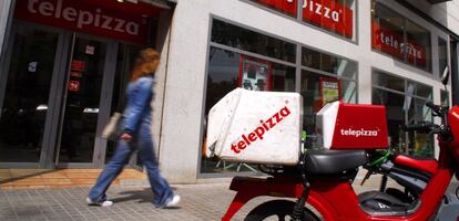 Una moto enfrente de un establecimiento de Telepizza.