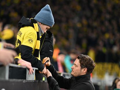 Edin Terzic, entrenador del Borussia Dortmund, firma un autógrafo a un joven aficionado del conjunto alemán en el Westfalenstadion.