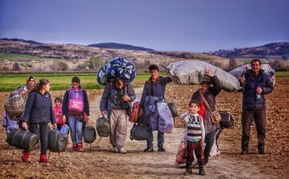 Una familia siria, que ha logrado escapar de una zona en conflicto, se encaminan hacia en campo fronterizo de Idomeni (Grecia).