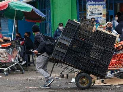 Un hombre jala un carro de carga repleto de cajas vacías, en el Mercado Central de Santiago (Chile), en una imagen de archivo.