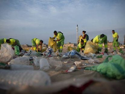 Operaris municipals netegen les platges de Barcelona.