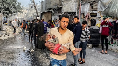 Un hombre lleva en brazos a una niña víctima de un bombardeo en Rafah, en el sur de la franja de Gaza, el 1 de diciembre.