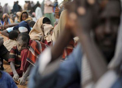 Un niño, con el rostro lleno de arena, espera junto a otros refugiados somalíes a formalizar en registro en el campo de refugiados de Dagahaley.