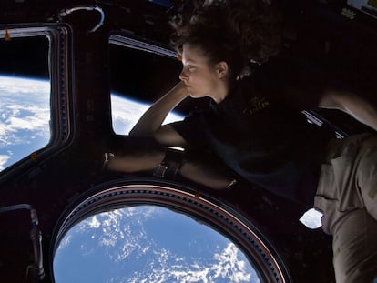 ISS024-E-014263 (11 Sept. 2010) --- NASA astronaut Tracy Caldwell Dyson, Expedition 24 flight engineer, looks through a window in the Cupola of the International Space Station. A blue and white part of Earth and the blackness of space are visible through the windows. 