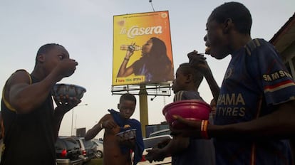 Unos menores comen un plato de arroz, su única comida al día, en Calabar (Nigeria).