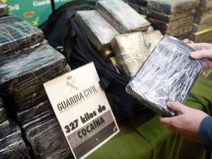Un guardia civil muestra uno de los 327 paquetes de cocaina incautados.