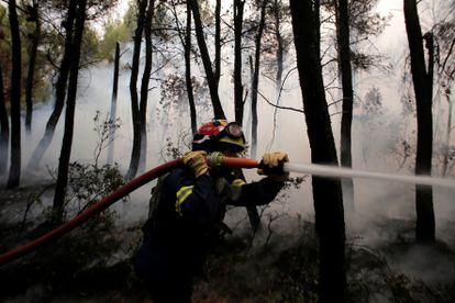 Un bombero lucha contra el fuego en la zona de Kryoneri, al norte de Atenas, el jueves.