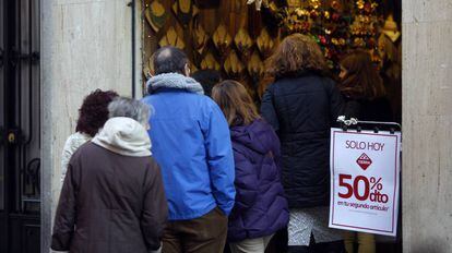 Clientes a la puerta de un comercio en Madrid.