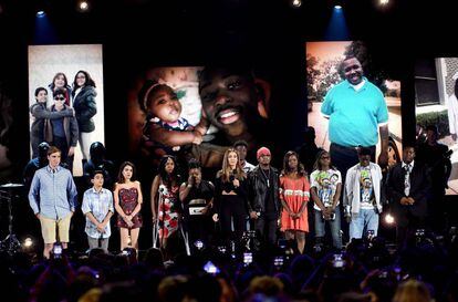 Jessica Alba (centro) habla en los Teen Awards, rodeada de familiares de víctimas de armas de fuego.