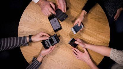 Varias personas utilizando sus teléfonos móviles