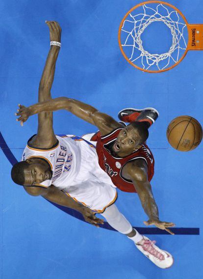 Kevin Durant de Oklahoma y Chris Bosh de los Miami Heat observan el lanzamiento a canasta de Durant.