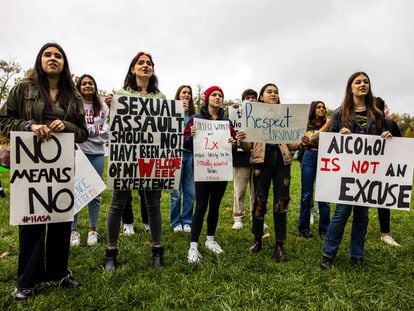 Women hold up signs with myths about rape during a 2021 protest for victims of sexual assault in Bloomington, Indiana.