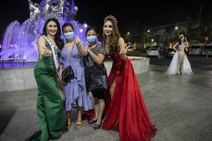 Dos bailarinas de cabaret posan con turistas con mascarillas en Tailandia, uno de los países con más enfermos de coronavirus del sudeste asiático.