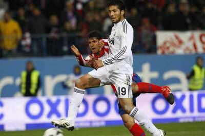 Garay defiende a Agüero en el Atlético-Madrid de la primera vuelta.