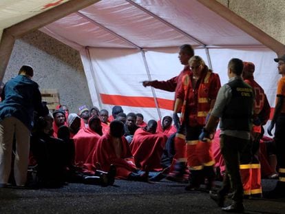 Miembros de la Cruz Roja y de la Guardia Civil atienden este jueves a un grupo de inmigrantes que ha llegado a Arguineguín (Gran Canaria).