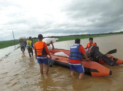 Los servicios de rescate llevan articulos de socorro a los habitantes afectados por las inundaciones en Kawayan.