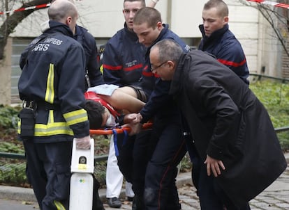 Los bomberos llevan a una víctima en una camilla después de un tiroteo en las oficinas de París de Charlie Hebdo.