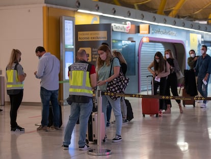 Control de seguridad en el aeropuerto de Barajas en octubre, con tiendas cerradas al fondo.