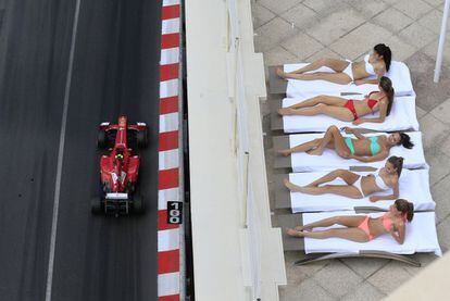 Montecarlo, Mónaco, 25 de mayo de 2013. Ningún Gran Premio de fórmula 1 representa mejor el circo de la competición como la cita de Mónaco: deporte, lujo y elitismo a partes iguales. En la imagen, un grupo de mujeres toma el sol en una exclusiva terraza mientras el piloto Felipe Massa participa en la sesión de clasificación del sábado. Al día siguiente, Rosberg se alzó con el triunfo, por delante de Vettel y Webber.