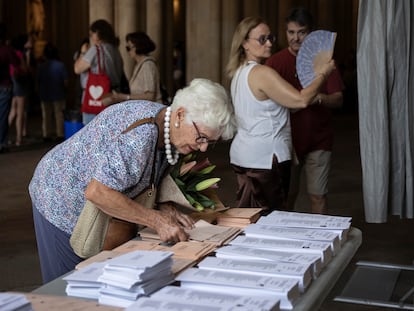 Una mujer escoge las pepeletas en en el colegio electoral de la sede de la UB en la plaza Universitat.