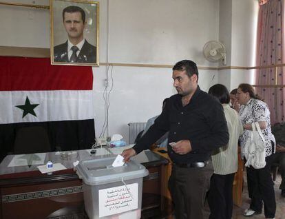 Un votante siriao ejerce su derecho al voto en un colegio electoral de Damasco.