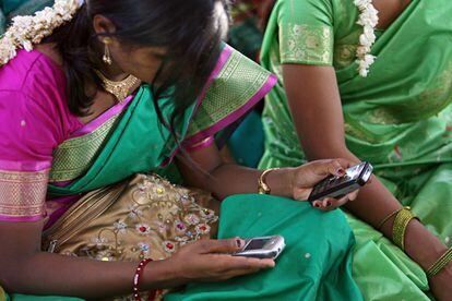 Una joven maneja dos teléfonos durante una reunión comunitaria en Aurangabad, India. El ‘big data’ que se obtiene a través de estos aparatos permite, por ejemplo, seguir movimientos de población y estimar el nivel económico de sus usuarios.