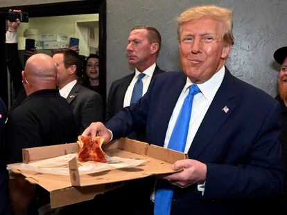 Donald Trump tomaba una porción de pizza el viernes tras intervenir en un foro del Partido Republicano en Fort Myers, Florida.