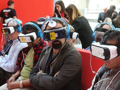 Varias personas ven un reportaje de realidad virtual en la exposición del 40 aniversario de EL PAÍS.