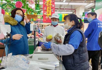 Una cliente y empleados con mascarillas en un supermercado de Pekín, el 29 de enero pasado.