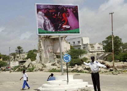 Un niño somalí pasa junto a un cartel del actual presidente Sharif Sheij Ahmed, en Mogadiscio.