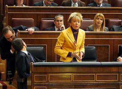 La vicepresidenta Fernández de la Vega, ayer en el pleno del Congreso, entre Zapatero (de espaldas) y Solbes.