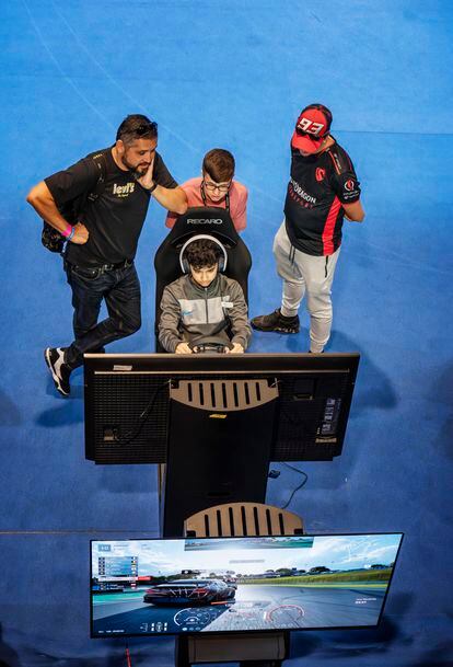 Attendees at the GT World Series final play in one of the simulators.